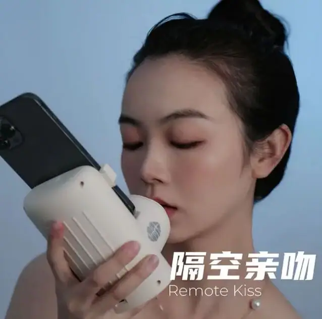 Long-distance lovers who have been waiting for a way to kiss their partners without being physically present now have an option. The Remote Kiss is a new kissing device that is designed to recreate the feeling of a real kiss using silicone lips studded with pressure sensors and tiny motors. The device has been patented by the Changzou Vocational Institute of Mechatronic Technology, and it has a Bluetooth app that links to the user's phone. The user can make a call through the app and opt to give their partner a full-on smooch.
The inventor of the device, Jiang Zhnogli, was inspired to create the product while he was in a long-distance relationship with his girlfriend. He says that the device was inspired by the fact that he and his girlfriend could only communicate with each other through the phone. The Remote Kiss is not only for long-distance couples; it is also designed to help people suffering from contagious diseases to be able to have a germ-free kiss.
The Remote Kiss is the latest invention in a series of new devices designed to transmit physical sensations of intimacy through the internet. CamSoda, an adult webcam site, has launched the Diamo, which is considered the world's "first ever" wearable "telepathic" sex toy for men. Sex tech pioneer Kiiroo has also reported a surge in searches for similar technology since the pandemic began.
The device also comes with an in-app "kissing square" that allows users to select a stranger to kiss at random. This feature adds an element of unpredictability to the device and allows users to explore their curiosity with other people.
The Remote Kiss has already received positive reviews from people who have tried it. One user said that it was the best surprise they had given their partner during their long-distance relationship. The device is a great example of how technology is helping to connect people across distances and provide innovative solutions to age-old problems.